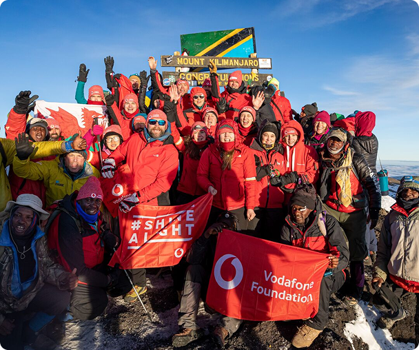 People waving vodafone foundation flag