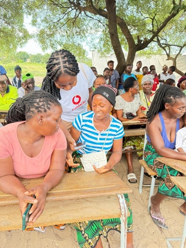 woman in vodafone foundation t-shirt helps community with their phones